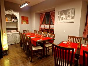 un restaurante con una mesa larga con mesas y sillas rojas en Ristorante Notari cà di gust vecc en Malvaglia