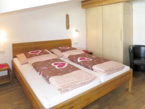 フューゲンベルクにあるApartment Apart Vorwies - FGZ137 by Interhomeのベッド(ブラウン&ホワイトの毛布、枕付)