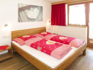 フューゲンベルクにあるApartment Apart Vorwies - FGZ137 by Interhomeのベッドルーム1室(ベッド1台、赤と白の毛布付)