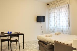 a bedroom with a bed and a table and a television at [50 metri da Fiera Milano] Comodo per due in Milan