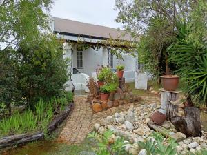 a house with a garden with rocks and plants at de Kleine Kelder in Riviersonderend