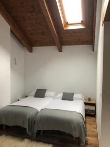 - une chambre avec un lit doté de draps blancs et une fenêtre dans l'établissement Casa Toronzue, à Frajén