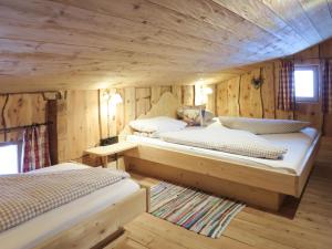 two beds in a room with wooden walls at Chalet Simonhütte - MHO640 by Interhome in Hippach