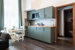 a kitchen with blue cabinets and a table in a room at Comfy New apartment at Castle in Budapest