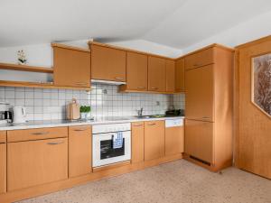 eine Küche mit Holzschränken und einem Backofen in der Unterkunft Apartment Markus - ZAZ760 by Interhome in Mühlfeld