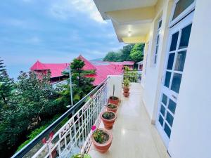 a balcony of a house with potted plants at Grand view lodge and Restaurant Dharamshala - Partial Prepayment required to confirm booking in Dharamshala