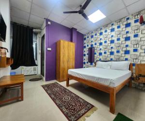 a bedroom with a bed and a purple wall at The kashi palace inn ,Varanasi ! fully-Air-Conditioned hotel at prime location with Parking availability, near Kashi Vishwanath Temple, and Ganga ghat in Varanasi