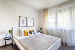 um quarto branco com uma cama grande e uma janela em Cute and convenient Apartment em Budapeste