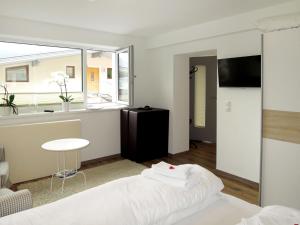 1 dormitorio con cama, mesa y ventana en Apartment Tamerl - MHO160 by Interhome, en Schwendau
