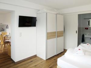 1 dormitorio con armarios blancos y TV en la pared en Apartment Tamerl - MHO160 by Interhome, en Schwendau