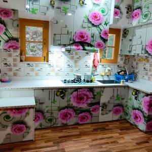 a kitchen with pink flowers on the wall at The Himalayan Inn homestay in Gulmarg