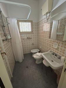 a bathroom with two toilets and a sink at Camere Capinera in Cesenatico