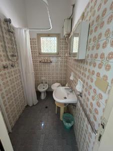 a bathroom with a sink and a toilet and a mirror at Camere Capinera in Cesenatico