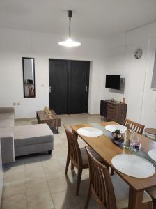 uma sala de estar com uma mesa e cadeiras e um sofá em Irene apartment in Vlachata village! em Cefalônia