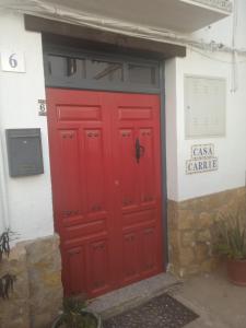 a red door on the side of a building at Casa Carrie in Válor