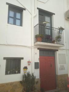 a white building with a red door and two windows at Casa Carrie in Válor