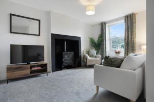 a living room with a television and a fireplace at Stylish Home near St Johns Chapel, Sleeps 6 in Saint Johns Chapel