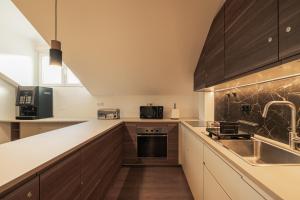 a kitchen with wooden cabinets and a sink at Monturi Hostel in Ponta Delgada