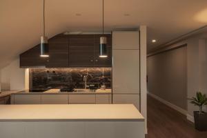 a kitchen with white cabinets and a counter top at Monturi Hostel in Ponta Delgada
