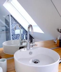 un lavandino in bagno con due rubinetti e uno specchio di ZwischenRaum a Wuppertal
