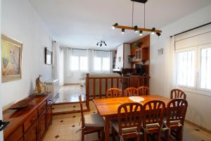 Il comprend une cuisine et une salle à manger avec une table et des chaises en bois. dans l'établissement Villa Dorada, à Mont-roig