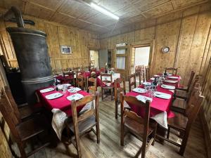 un comedor con mesas y sillas en una sala de madera en Rifugio Teggiate, en Madesimo