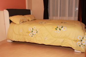 a bed with a yellow comforter with flowers on it at Kijabe Sunset View Guesthouse in Kijabe