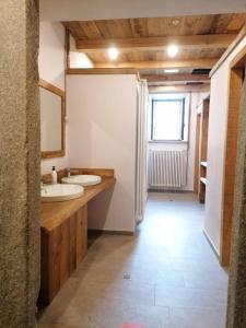 Baño con 2 lavabos y espejo en Rifugio Teggiate en Madesimo