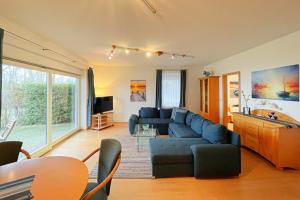 un soggiorno con divano blu e una cucina di Haus Berlin Ferienwohung 1 a Kölpinsee auf Usedom