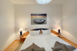 una camera da letto con un grande letto bianco con due lampade di Haus Berlin Ferienwohung 1 a Kölpinsee auf Usedom
