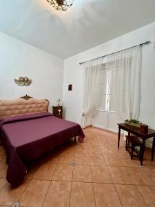 een slaapkamer met een paars bed en een tafel bij Casa del Duomo in Siracusa