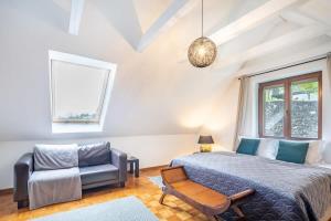 a bedroom with a bed and a couch and a chair at Slow living - perfect vacation in Somlószőlős