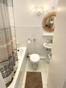 y baño con aseo, lavabo y espejo. en Napsugár Retro Apartman, en Gárdony