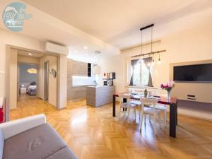 a living room with a dining room table and a kitchen at Viale Miramare 123/1 Tirabora Short Rent in Trieste