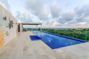 a swimming pool with a view of the ocean at Happy Vibes Getaway with Stellar Oceanview Roof Pool! in Playa del Carmen