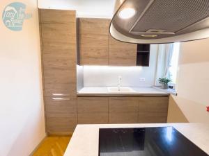 una cocina con armarios de madera y fregadero en Viale Miramare 123/1 Tirabora Short Rent, en Trieste
