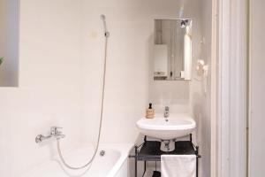 bagno bianco con lavandino e doccia di Central Cozy Home a Budapest