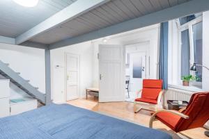 ein Schlafzimmer mit einem Bett und einem roten Stuhl in der Unterkunft Central Cozy Home in Budapest