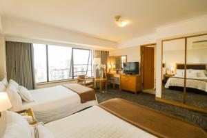 een hotelkamer met 2 bedden en een televisie bij Hotel Miramar in Lima