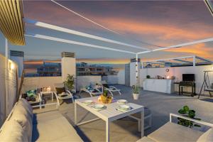 een balkon met een tafel en stoelen op een dak bij Baliante - penthouse, 2 bedrooms, 2 pools, jacuzzi, Orihuela Costa in Orihuela