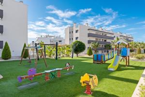 a playground in a park in front of a building at Baliante - penthouse, 2 bedrooms, 2 pools, jacuzzi, Orihuela Costa in Orihuela