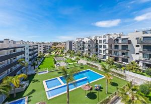 een appartement met een binnenplaats met een zwembad en palmbomen bij Baliante - penthouse, 2 bedrooms, 2 pools, jacuzzi, Orihuela Costa in Orihuela