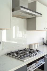 a white kitchen with a stove top oven at London & Forest in Loughton