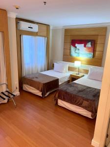 a hotel room with two beds and a television at UNU Congonhas in São Paulo