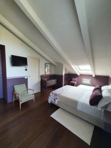a bedroom with a large bed and a chair at A440 in Tuscany in Pienza