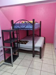 a room with two bunk beds in a pink wall at Comodidad, espacio y privacidad in La Palmita