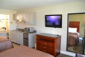 una habitación de hotel con cocina y una habitación con 2 camas en Dayspring Extended Stay, en Greensboro