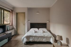 een slaapkamer met een wit bed en een televisie bij CENTRAL Studio - Fully equiped. Ideal for couples in Patra