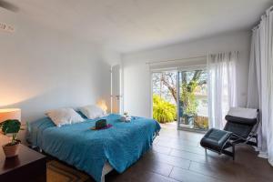 ein Schlafzimmer mit einem Bett, einem Stuhl und einem Fenster in der Unterkunft VILLA MARGUERITE VI4406 By Riviera Holiday Homes in Villefranche-sur-Mer