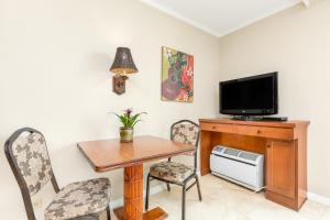 a dining room with a table and a tv at Luana Waikiki Hotel & Suites in Honolulu